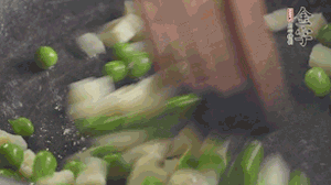 鍋中油7成熱時(shí)，入青豆、筍丁翻炒，然后加糯米飯加鹽均勻翻炒。