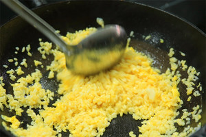 大火加熱炒鍋，再入油，燒到四至五成熱時倒入雞蛋液，在未凝結(jié)之前，加米飯煸炒，不停翻炒并用鍋鏟將成塊的米飯碾開、撥散。