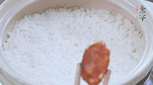 煮開(kāi)后轉(zhuǎn)小火，當(dāng)米飯出現(xiàn)小孔時(shí)，鋪上金字麻辣香腸。