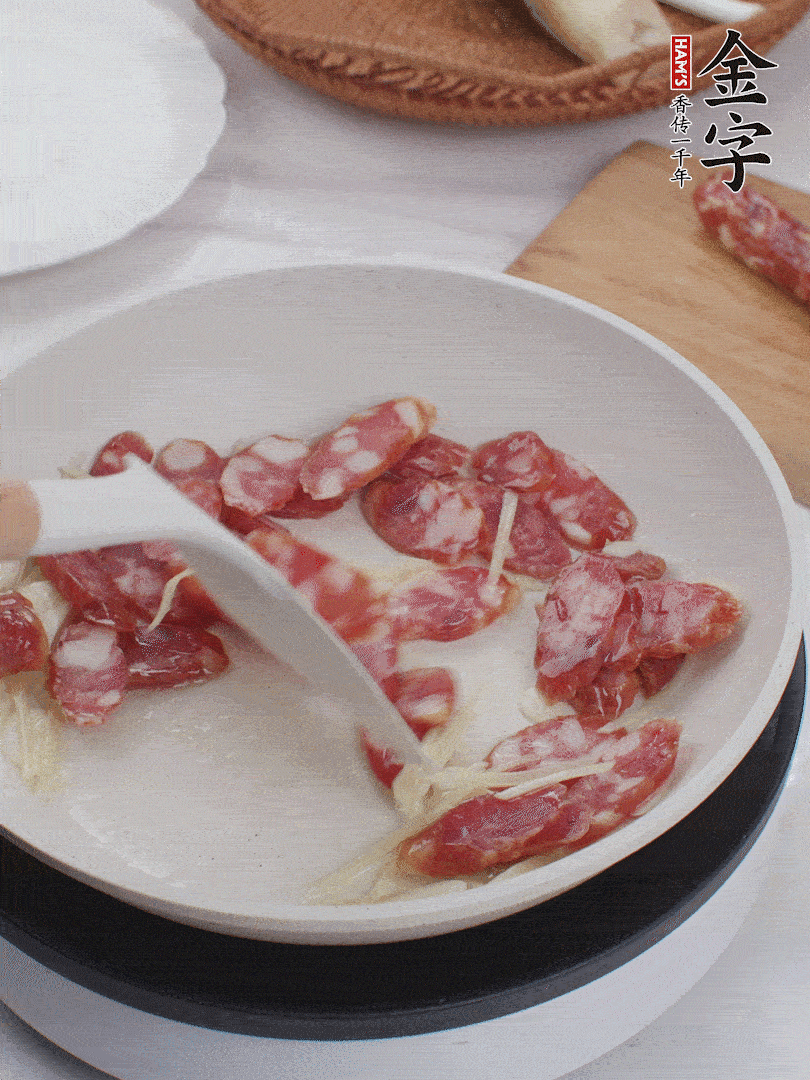 油溫3成熱時，下姜絲、蒜片、香腸炒出油脂。