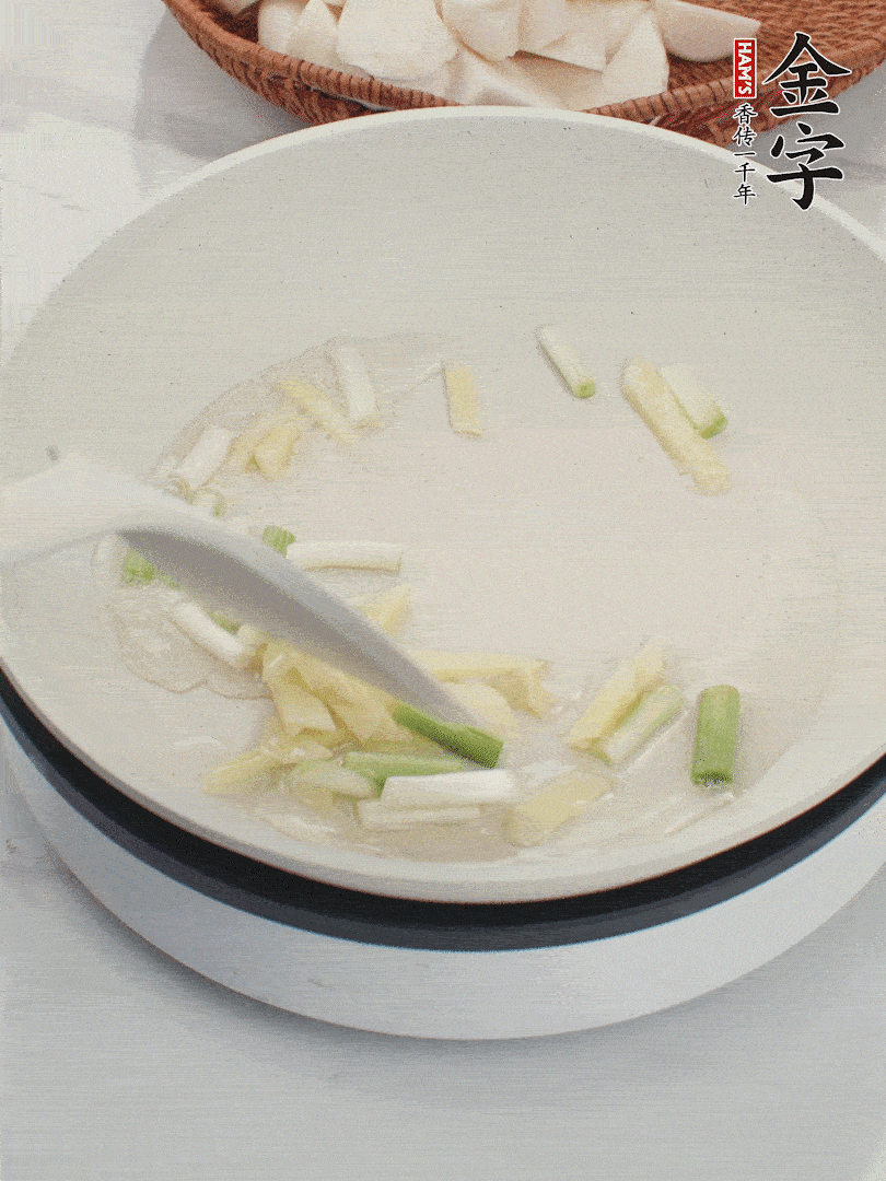 鍋中油五成熱，下蔥白、姜片爆香。