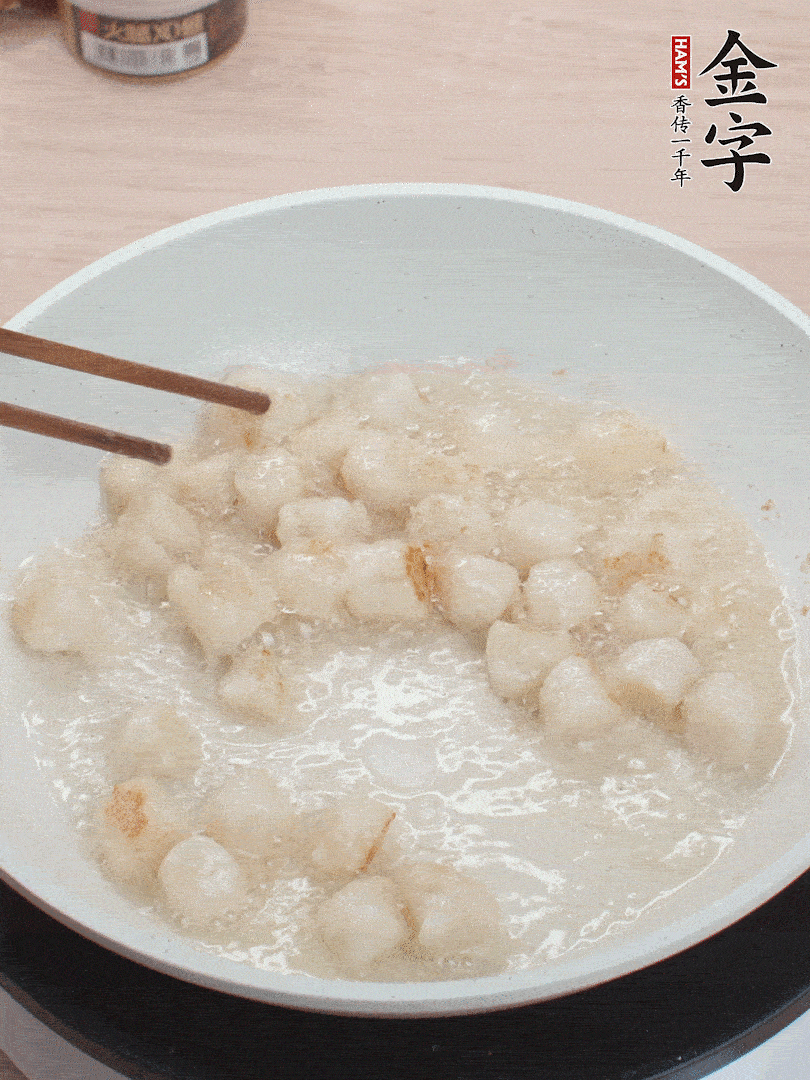 油溫4成熱，鮮貝蘸干淀粉下鍋煎，一面微黃后翻面。