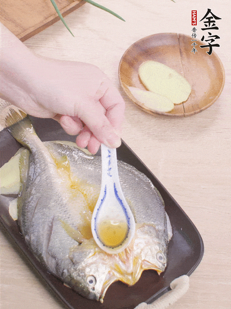 盤(pán)底鋪姜片，放黃魚(yú)，淋2勺料酒。