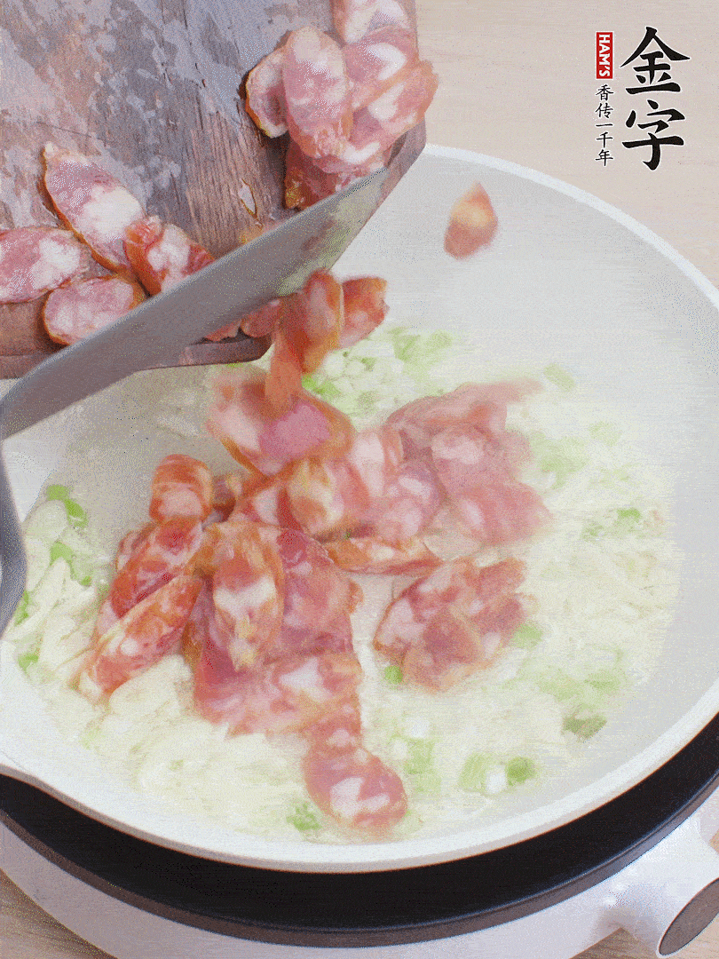 油5成熱，蒜末、蔥白爆香，下香腸炒出香味。