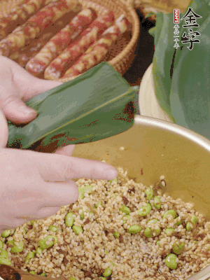 粽葉往下折，完全蓋住，兩側(cè)捏緊。