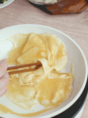 油6成熱時(shí)，下雞蛋液，邊緣凝固時(shí)翻拌成塊狀。