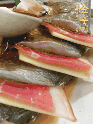 魚肚中塞蔥結(jié)、火腿片，魚身上碼放姜片、火腿片，倒入混合的料汁。