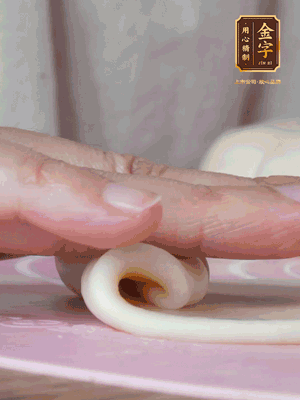 做面劑 油皮按扁，中間包入一個(gè)油酥，邊緣收緊捏死。包好的面劑按扁，用搟面杖搟壓成橢圓形。從底部向上卷成筒狀，用保鮮膜蓋好松弛15分鐘，再把筒狀縱向搟壓成長條狀。再卷一次，松弛20分鐘