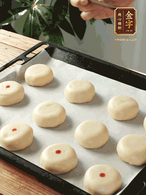 收口向下放在案板上，輕輕將月餅坯按扁，用筷子點(diǎn)紅點(diǎn)做裝飾
