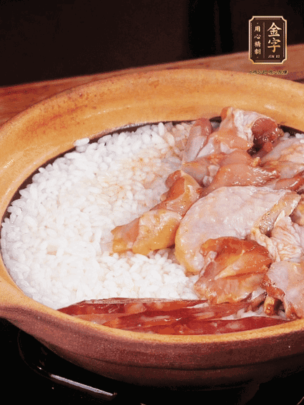 煮到椰子水微微收干轉(zhuǎn)小火，快速均勻鋪上雞肉、金字香腸